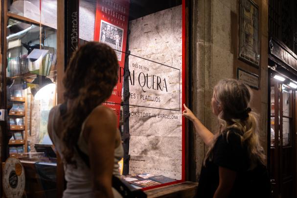 Due visitatrici osservano «1.056 toponimi del Siurana» nella vetrina dell’Espai Quera.