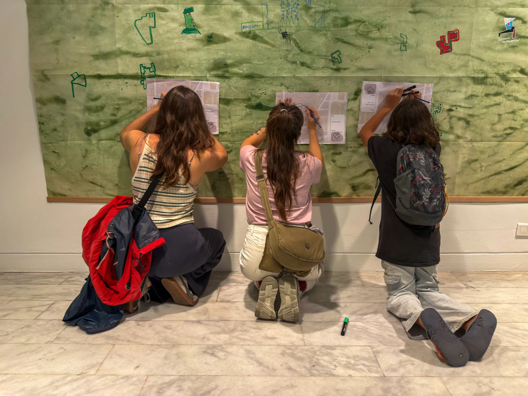 Participants drawing at the foot of one of the cartographies. Drawing while Walking, Museu Picasso, Barcelona, 2026